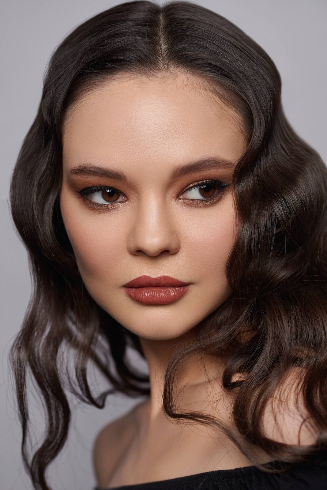 Close-up: bronze eyes, terracotta lips, soft waves